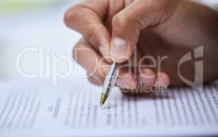 Read through our terms and sign when youre ready. Closeup shot of an unrecognisable man going through paperwork.