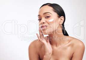 I already see a difference in the appearance and feel of my skin. Studio shot of a beautiful young woman applying moisturiser to her face.