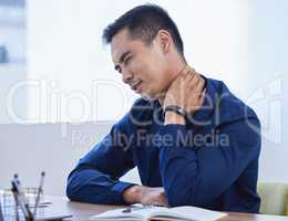 I could cry with how painful this is. a young businessman experiencing neck pain while working in an office.