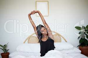 I feel well-rested. a young woman stretching out her arms after waking up.
