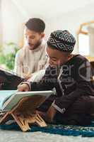 You can only provide the right conditions for learning. a young muslim man and his son reading in the lounge at home.