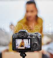Lets see whats in the box. a young woman recording a video for her vlog at home.