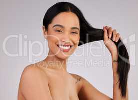 Healthy hair is something to smile about. Studio shot of a beautiful young woman posing against a grey background.