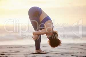 Know what leads you forward and what holds you back. a young female doing yoga on the beach.