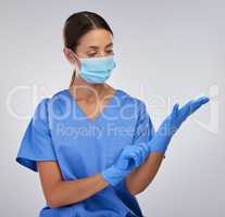 I have to protect myself at all costs. a female nurse putting on her protective gloves.