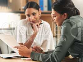 What do you think of this proposal. two female coworkers surveying paperwork.