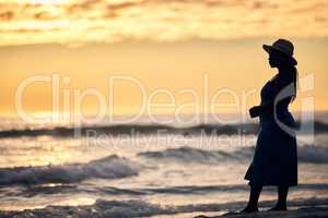 Turning experience into insight. an unrecognizable woman walking along the beach at sunset.