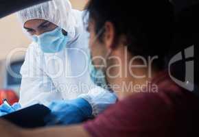 I have no symptoms doctor. a doctor recording a patients information for a drive through vaccination.