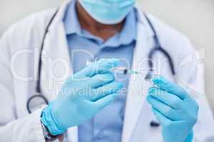 A vaccination could save a live. an unrecognizable doctor using a syringe to extract medication from a vial.