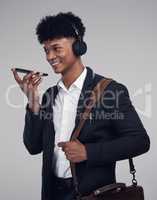 Every travelling entrepreneur needs a virtual assistant. Studio shot of a young businessman using a smartphone and headphones against a grey background.