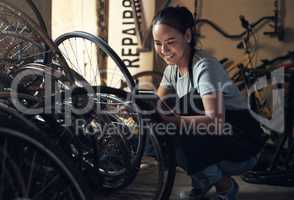 Makeup has never thrilled me. a young happy young woman fixing a bike at a bicycle repair shop.