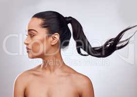 My hair is as wild as my personality. Studio shot of a beautiful young woman posing against a grey background.