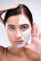 Commit to a routine thatll benefit the health of your skin. Studio shot of a young woman wearing a face mask while standing against a white background.