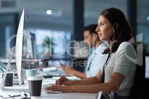 Focus on the reward, its right in front of you. a young businesswoman using a computer in a modern office.