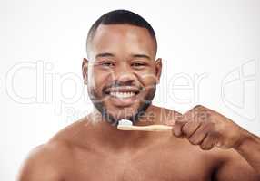 His charming smile is his best feature. Studio portrait of a handsome young man brushing his teeth against a white background.