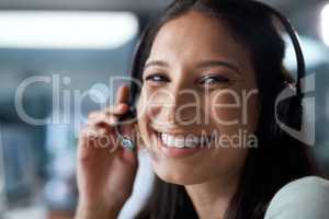 Relax, youve called the right place. Portrait of a young woman using a headset in a modern office.