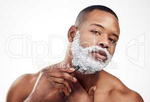 Because nobody wants to look like a total caveman. Studio portrait of a handsome young man shaving his facial hair against a white background.