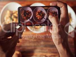 If this doesnt entice your tastebuds, what will. an unrecognisable man using a smartphone to take pictures of a healthy meal he prepared at home.