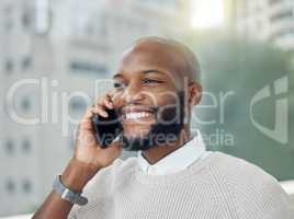 Lets set up a meeting. a handsome young businessman making a phonecall while standing on the balcony of his office.