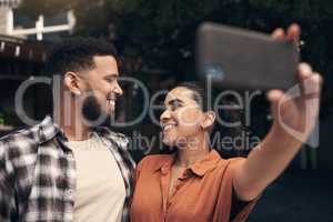 We have to capture the perfect day out. two young friends standing outside a restaurant and using a cellphone to take a selfie.