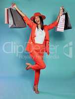 Excited and trendy woman with shopping bags after retail therapy, spending and buying clothes. Stylish, edgy and funky model holding gifts and wearing colorful, fashionable red suit while happy