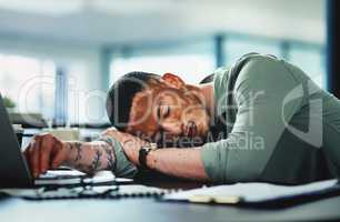 Never sleep on your ability to succeed. a young businessman sleeping in an office at work.