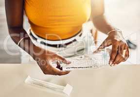 Closeup of casual adult woman unpacking a covid test kit. Female preparing vaccine for corona testing for virus at home. Lady getting ready to self diagnose an illness, sickness or viral disease.