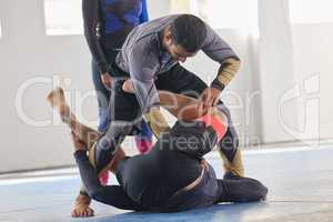 Seeing how far theyve come. an unrecognizable jiu jitsu sensei observing two of his students sparring during a class.