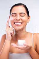 Invest in the health of your skin. a beautiful young woman applying moisturiser to her face.