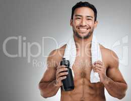 Dont delay your sweat sessions. an athletic man holding a bottle of water while standing against a grey background.