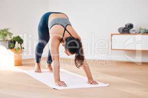 Calm your mind with some yoga. a young woman practicing the downward dog position during her yoga routine.