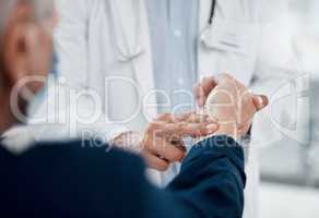 Your pulse seems normal. an unrecognizable doctor checking a patients pulse in an office.