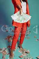 Closeup of hands holding, showing and displaying money while standing against a blue studio background alone. One stylish, trendy and fashionable female donating or giving cash in a competition