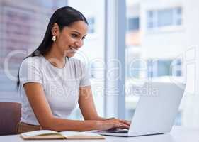Working diligently. an attractive young businesswoman working on her laptop while sitting in the office.