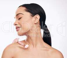 You should add this multi-use device to your skincare regimen. Studio shot of a young woman posing with a derma roller against a white background.