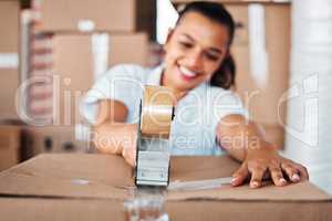 Im ready for a fresh start. a young woman sealing cardboard boxes with sellotape at home.