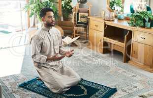 Once prayer becomes a habit, success becomes a lifestyle. a young muslim man praying in the lounge at home.