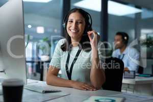 We leave no room for sub par support. Portrait of a young woman using a headset and computer in a modern office.