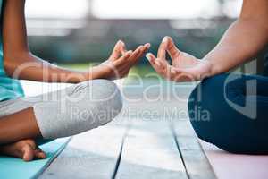 Finding peace from within. two unrecognizable people meditating at home.