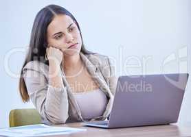 In a slump and lacking motivation. a young businesswoman looking bored while working in an office.