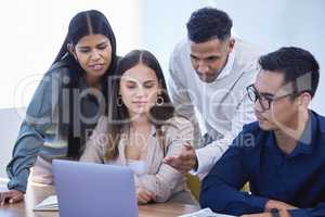 Developing a solid plan to match their great objectives. a group of businesspeople working together on a laptop in an office.