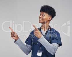 This one comes highly recommended. a male nurse pointing at copy space while standing against a grey background.