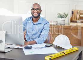 Wait till you see what we can do for you. Portrait of a businessman smiling while sitting at his desk.