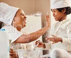 Love is the secret ingredient to our family recipe. a mother and her daughter baking in the kitchen at home.