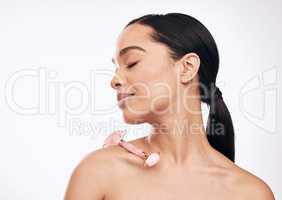 Use this tool for smoother, firmer, and younger-looking skin. Studio shot of a young woman posing with a derma roller against a white background.