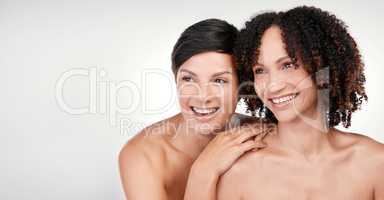 Take a look, beauty is that way. two beautiful mature women posing against a grey background in studio.