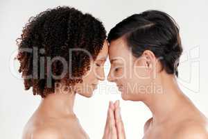 Face to face with beauty. two beautiful mature women posing against a grey background in studio.