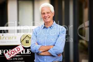 Its the home Im gonna retire in. Cropped portrait of a handsome senior man standing with his arms crossed next to a sold sign outside of his newly purchased home.