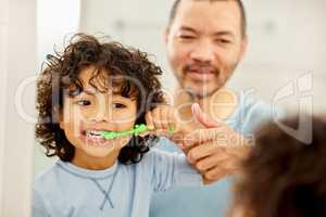 Brush your teeth everyday, To keep dentist away. a father teaching his son how to brush teeth at home.