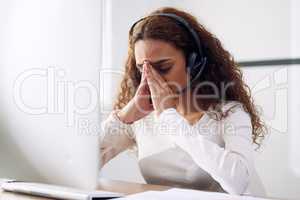 Sometimes your own problems are the ones that need solving. an attractive young female call center agent looking stressed while working at her desk in the office.